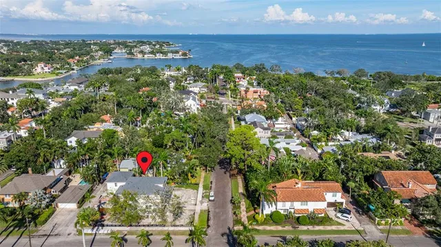 an aerial view of residential houses with outdoor space and trees