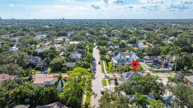 an aerial view of residential houses with outdoor space and trees