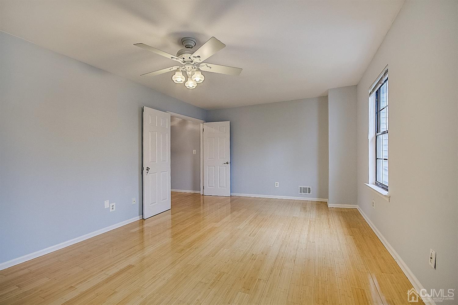 3102 Stonehedge Road Edison, NJ 08820 - Photo 22 of 41 a view of an empty room with wooden floor and a window