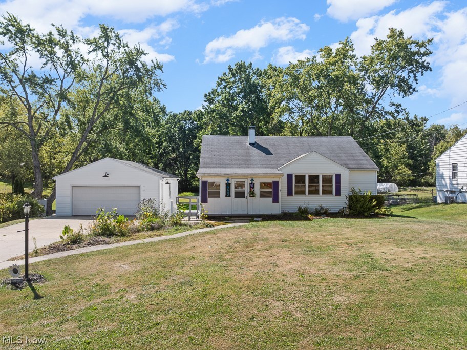 1702 Far View Road Akron, OH 44312 - Photo 1 of 49 View of front of property featuring an outbuilding, a front lawn, a detached garage, and view of wooded area
