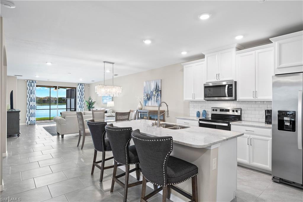 14558 Edgewater Circle Naples, FL 34114 - Photo 8 of 40 a large kitchen with a table and chairs