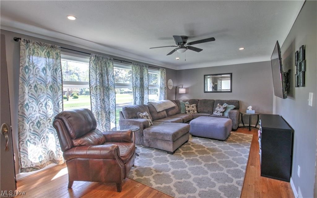 Living area with recessed lighting, ceiling fan, and light wood-style floors