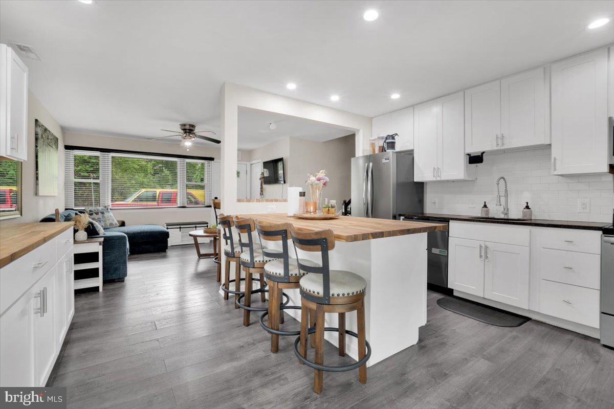 18907 Barnette Circle Triangle, VA 22172 - Photo 6 of 39 a kitchen with stainless steel appliances kitchen island granite countertop a table chairs sink and cabinets