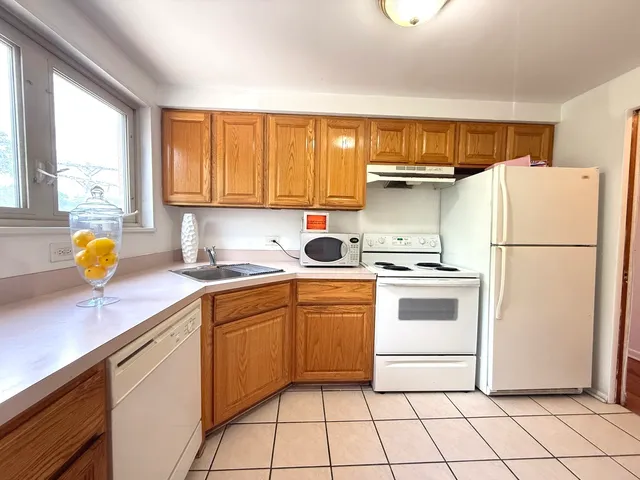 a kitchen with a refrigerator sink and cabinets