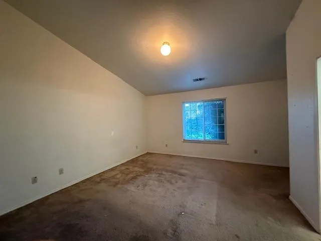 an empty room with windows and fireplace