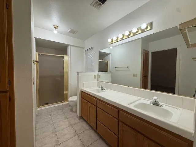 a spacious bathroom with double vanity and a mirror