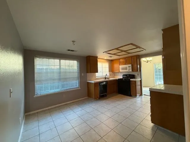 a kitchen with granite countertop a refrigerator and a stove top oven