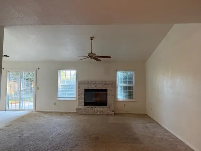 an empty room with windows and fireplace