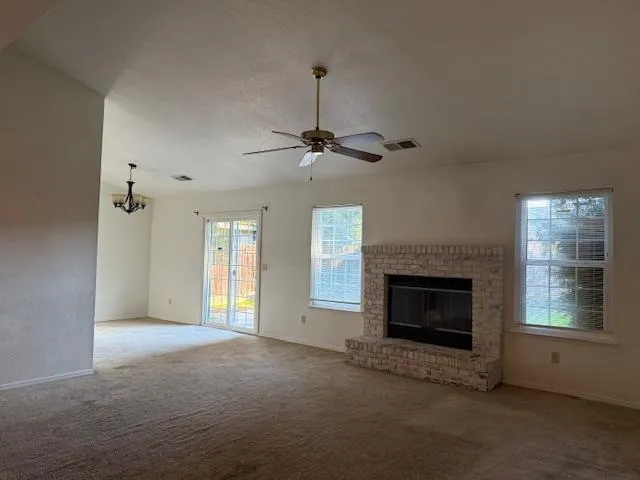 a view of an empty room with a fireplace and a window