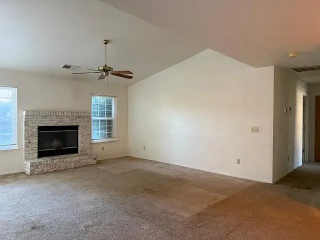 a view of an empty room with a fireplace and a window