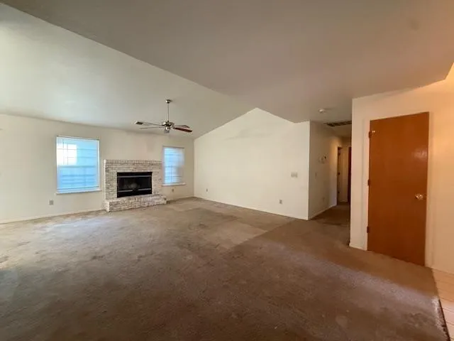 an empty room with fireplace and window