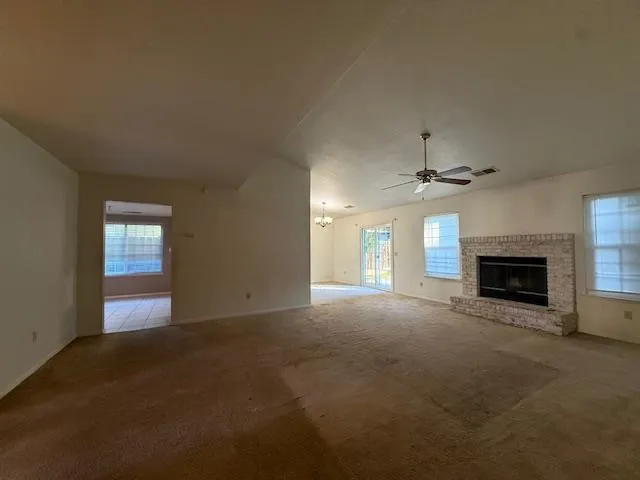 an empty room with windows and fireplace