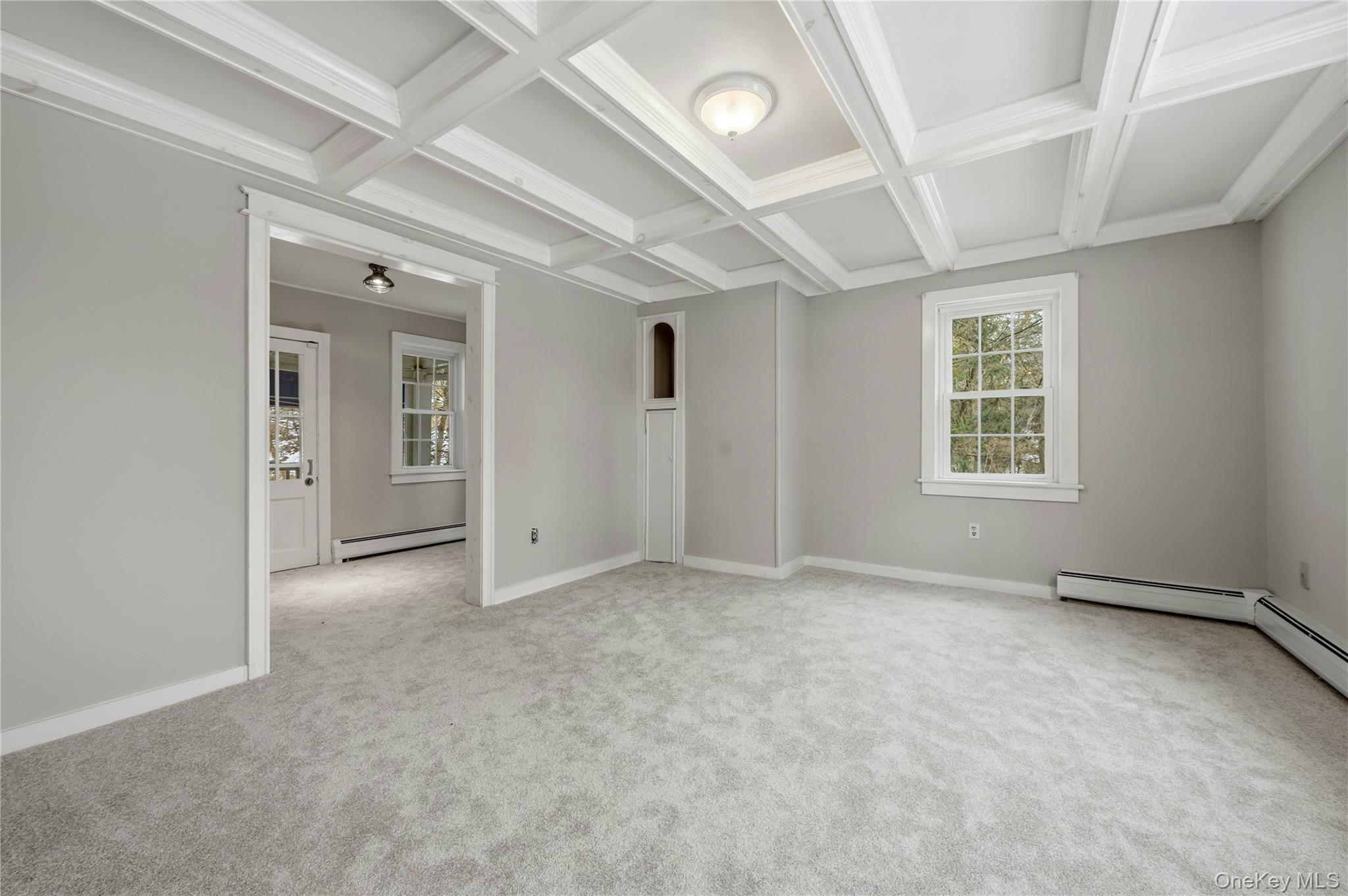 293 Highway 94 Warwick, NY 10990 - Photo 6 of 20 Unfurnished room featuring coffered ceiling, beam ceiling, a baseboard radiator, light carpet, and crown molding