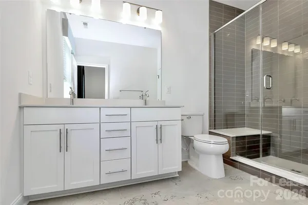 a bathroom with a toilet sink and double vanity