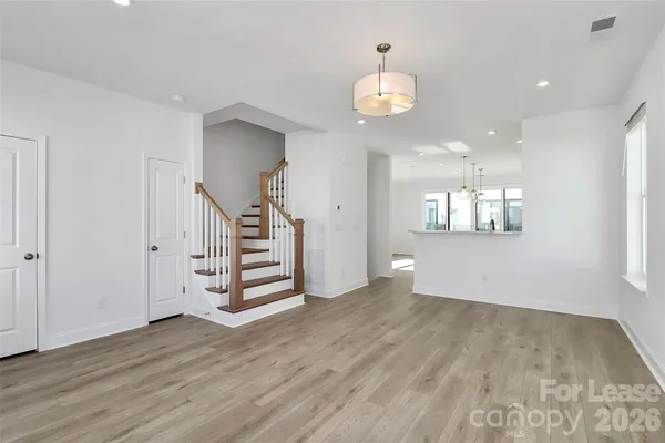 an empty room with wooden floor and stairs