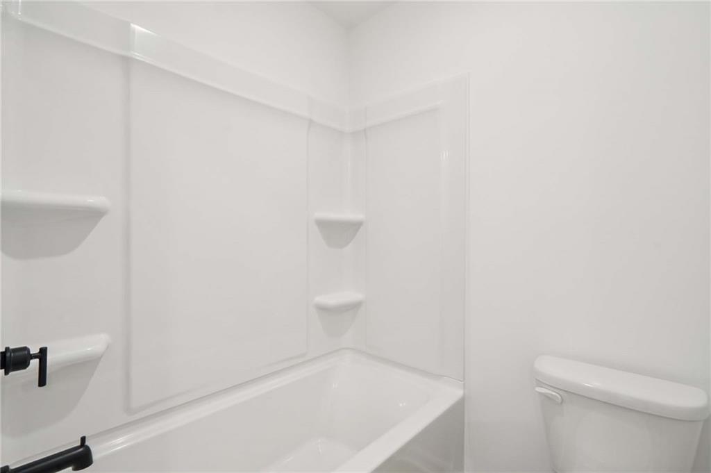 308 Silverleaf Trail Bethlehem, GA 30620 - Photo 28 of 36 a bathroom with a white bath tub and a toilet