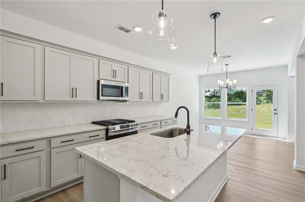308 Silverleaf Trail Bethlehem, GA 30620 - Photo 4 of 36 a kitchen with stainless steel appliances granite countertop a sink a stove and a wooden floors