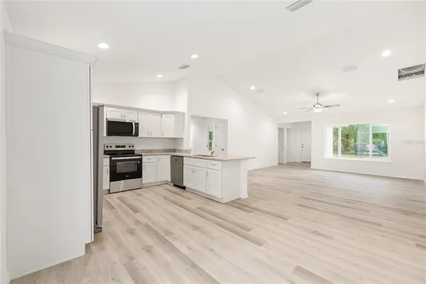 a large kitchen with kitchen island a sink stainless steel appliances and cabinets