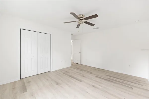 a view of a big room with wooden floor closet and windows