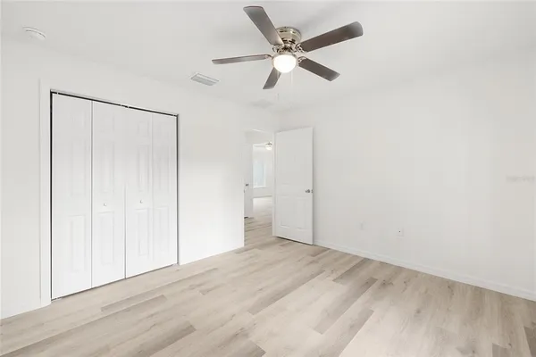 a view of an empty room and a ceiling fan window