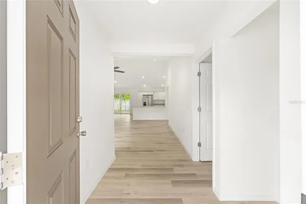 a view of a hallway with wooden floor and staircase