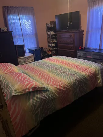 a bed sitting in a bedroom and wooden floor