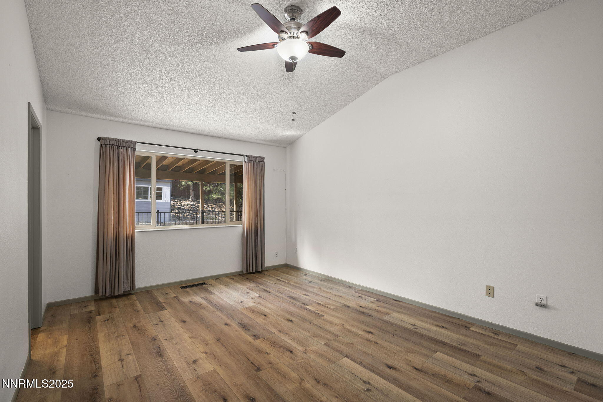 7690 Deep Bay Drive Reno, NV 89506 - Photo 15 of 26 an empty room with wooden floor chandelier fan and windows