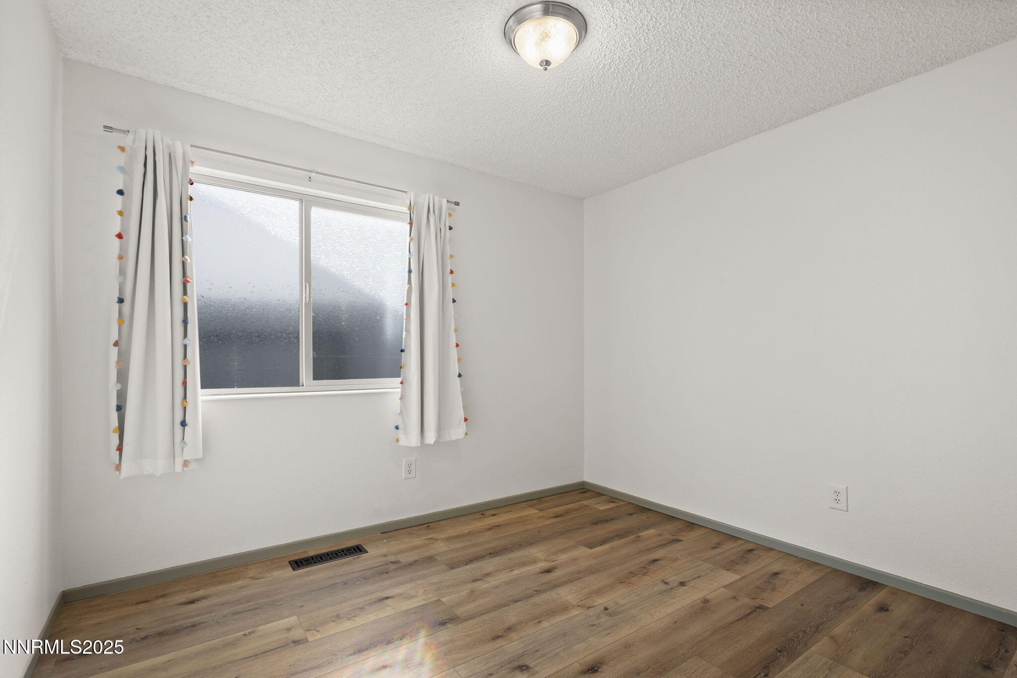7690 Deep Bay Drive Reno, NV 89506 - Photo 18 of 26 an empty room with wooden floor and mirror