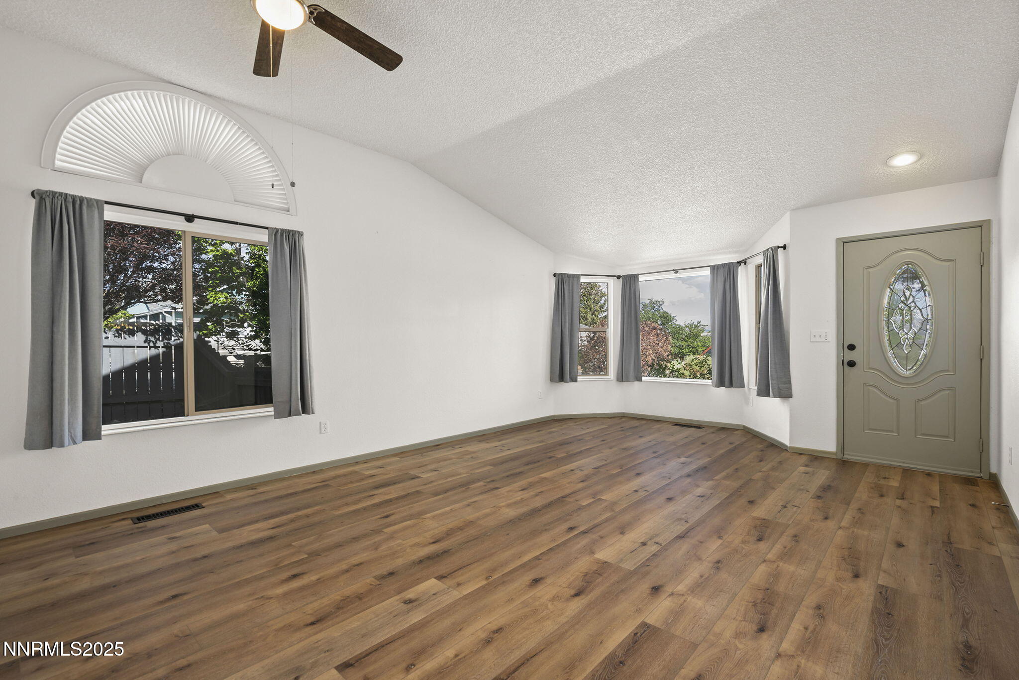 7690 Deep Bay Drive Reno, NV 89506 - Photo 3 of 26 an empty room with wooden floor cabinet and windows