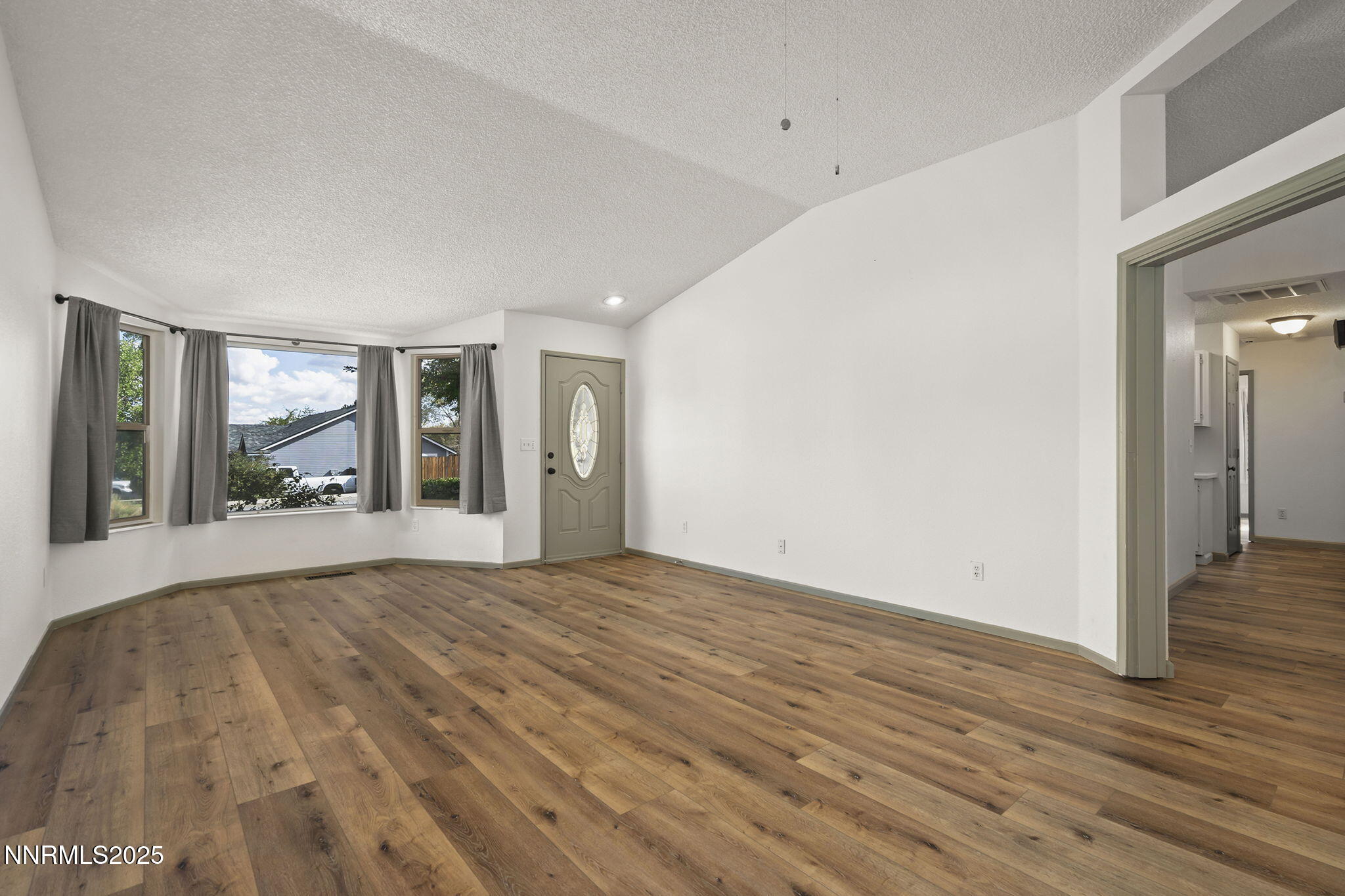 7690 Deep Bay Drive Reno, NV 89506 - Photo 4 of 26 a view of an empty room with wooden floor and a window