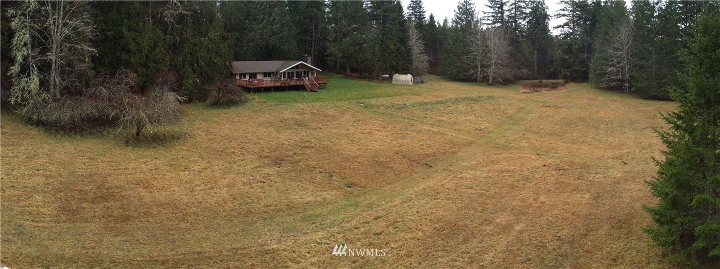 991 Lords Lake Loop Road Quilcene, WA 98376 - Photo 8 of 34 a backyard of a house with trees and barbeque
