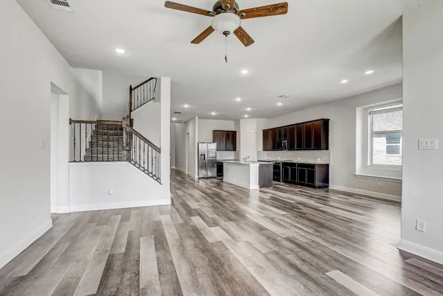 a view of a living room a ceiling fan and wooden floor