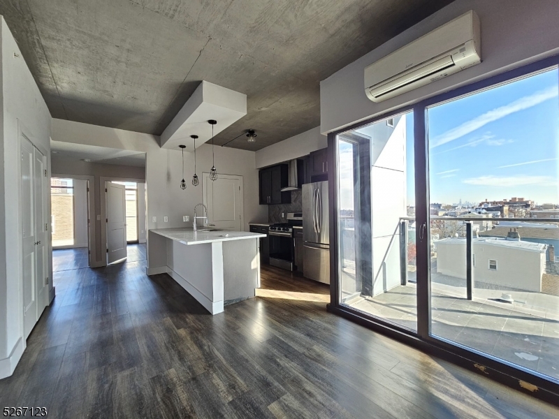58 Elm Street, Unit 601 Newark, NJ 07105 - Photo 3 of 15 a large kitchen with a large window and wooden floor