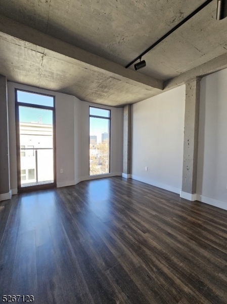 58 Elm Street, Unit 601 Newark, NJ 07105 - Photo 7 of 15 a view of an empty room with wooden floor and a window