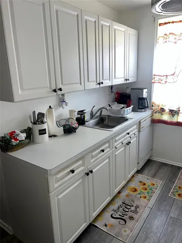 a kitchen with stainless steel appliances a sink a stove a window and cabinets