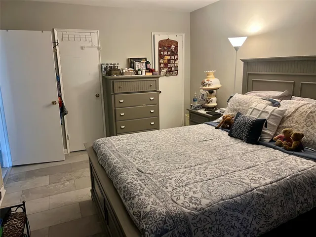a bedroom with a bed and a refrigerator