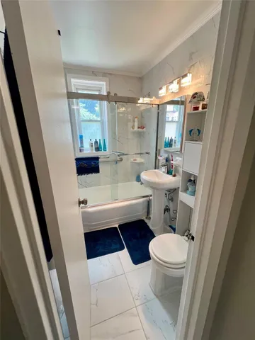 a bathroom with a sink a toilet a tub and shower