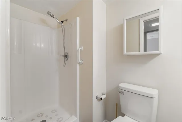 a bathroom with a toilet and a shower