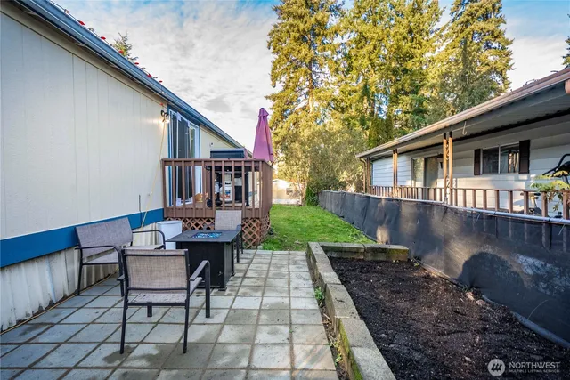 a view of a patio with table and chairs with wooden floor and fence