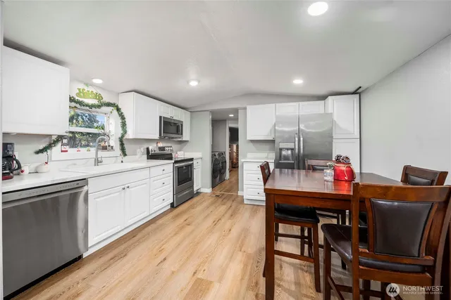 a kitchen with a table chairs refrigerator and cabinets