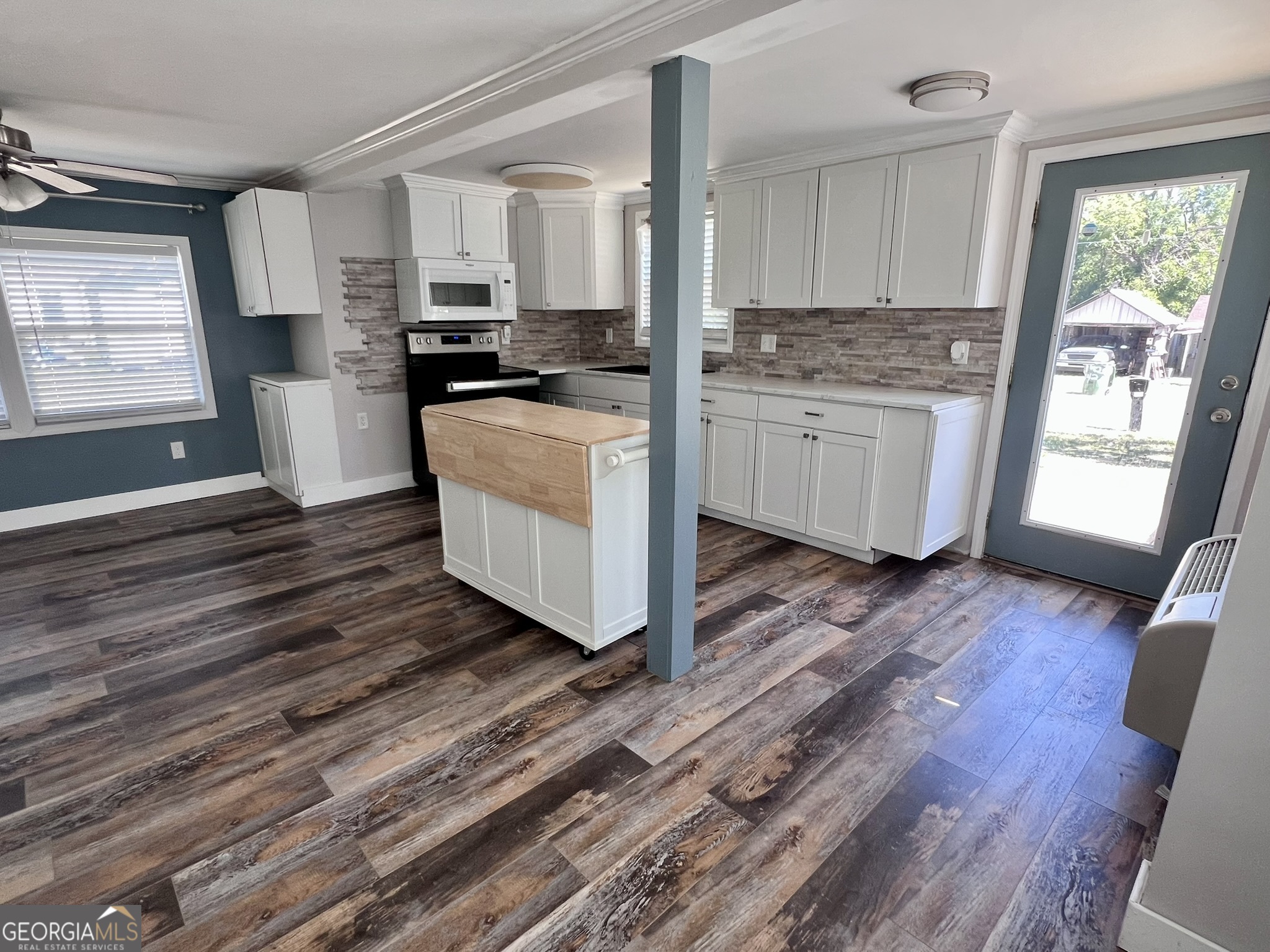 145 Sycamore Street Jesup, GA 31545 - Photo 4 of 14 a kitchen with wooden floors and white appliances