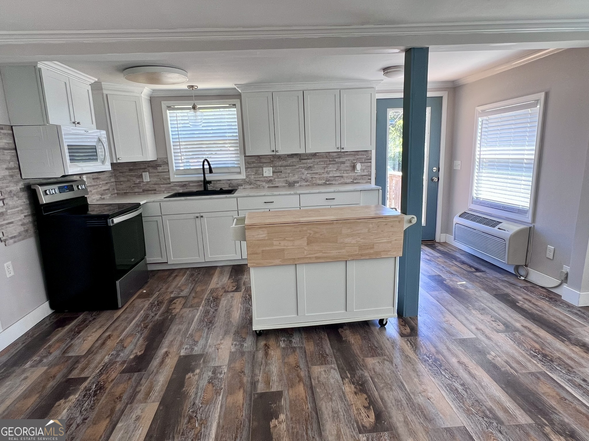 145 Sycamore Street Jesup, GA 31545 - Photo 5 of 14 a kitchen with wooden floors and refrigerator