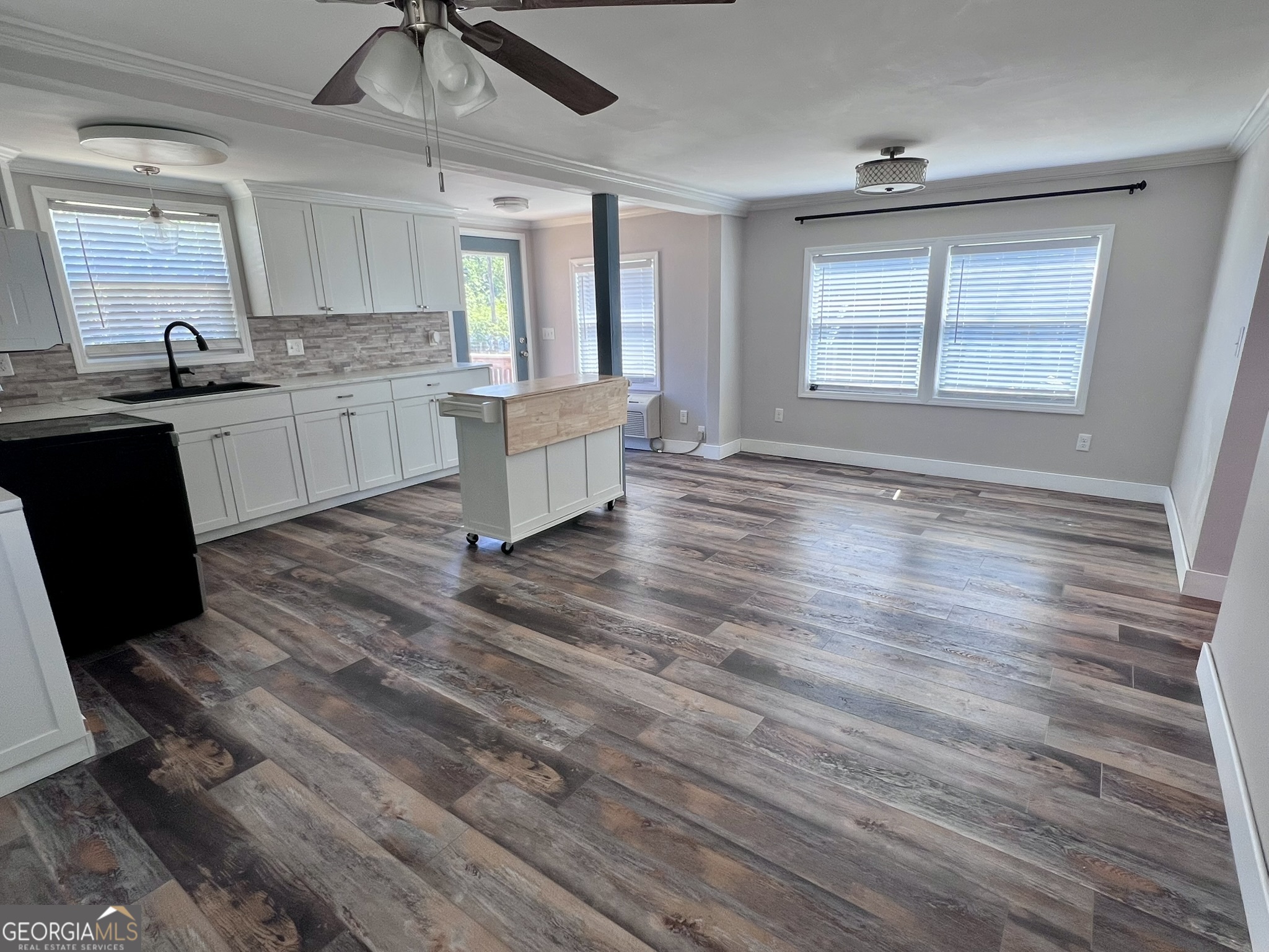 145 Sycamore Street Jesup, GA 31545 - Photo 7 of 14 a large kitchen with hardwood floor sink and window