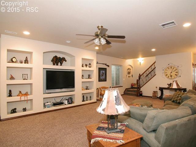 9863 Rockingham Drive Peyton, CO 80831 - Photo 16 of 21 Spacious family room in basement with built-in entertainment center & large tiled wet bar.