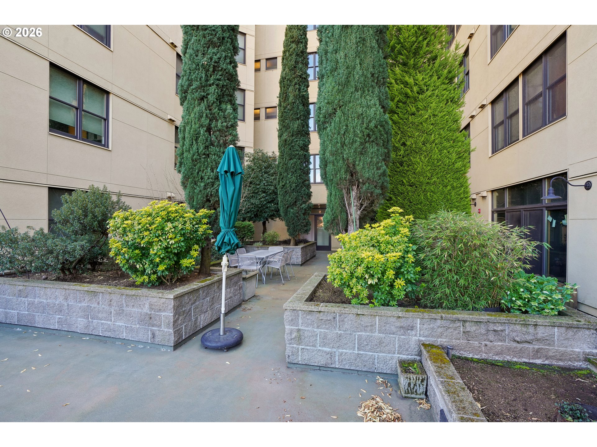 411 Northwest Flanders Street, Unit 302 Portland, OR 97209 - Photo 35 of 41 a backyard of a house with a garden and plants