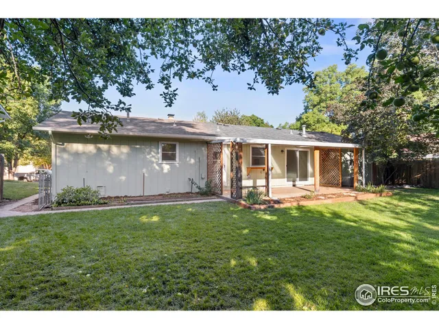 a view of a house with backyard and a tree