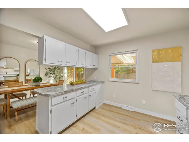 a kitchen with stainless steel appliances granite countertop a stove a sink and white cabinets