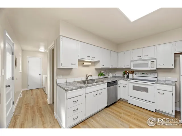 a kitchen with stainless steel appliances granite countertop a stove a sink and white cabinets