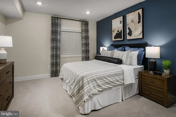 a spacious bedroom with a bed and painting on the wall