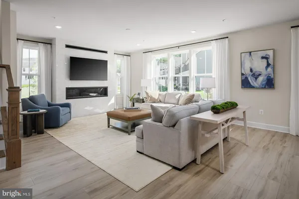 a living room with furniture a flat screen tv and a large window